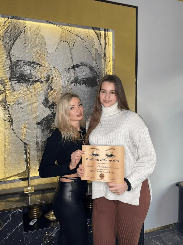 Absolventin der Schulung mit Zertifikat vor der goldenen Studiowand